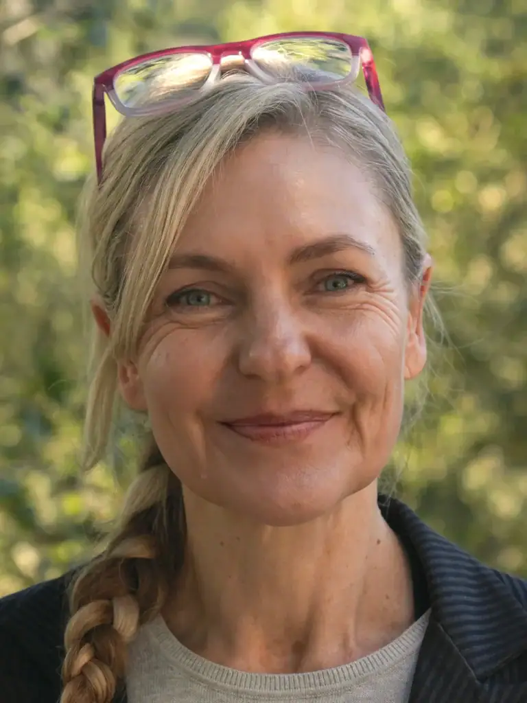 Therapist Nicole Cheung, Psy.D. smiling in nature setting.