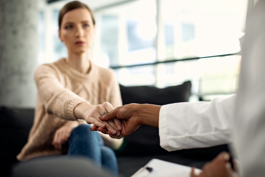 Therapist and patient shaking hands during therapy session.